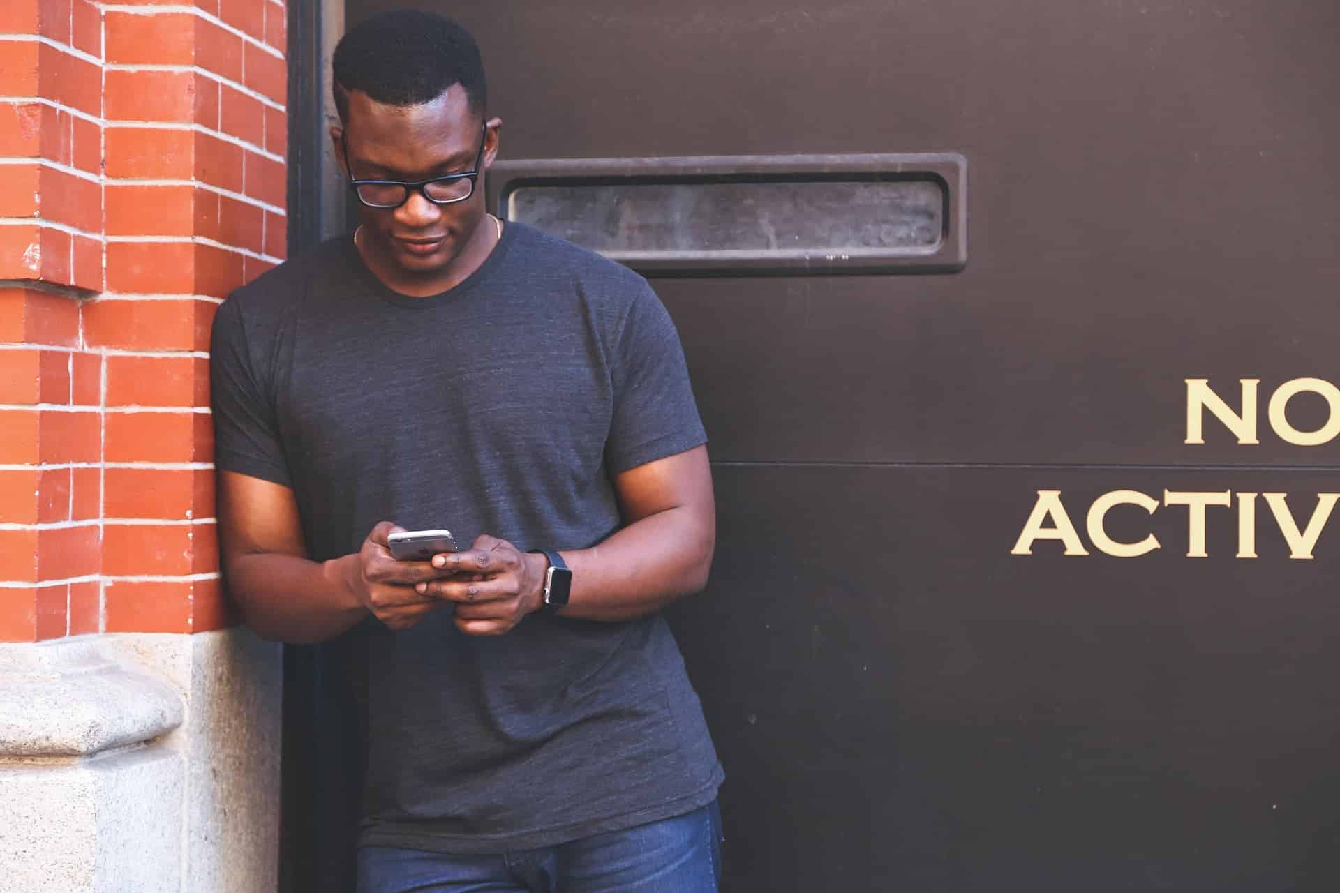 Homme utilisant un smartphone pour accéder aux solutions numériques.